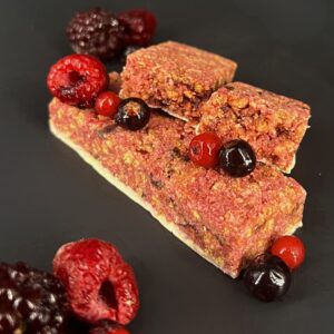 Barre crisp protéinée saveur fruits rouges, présentées avec des fruits rouges, 1Defy nutrition sportive made in bourgogne, made in france