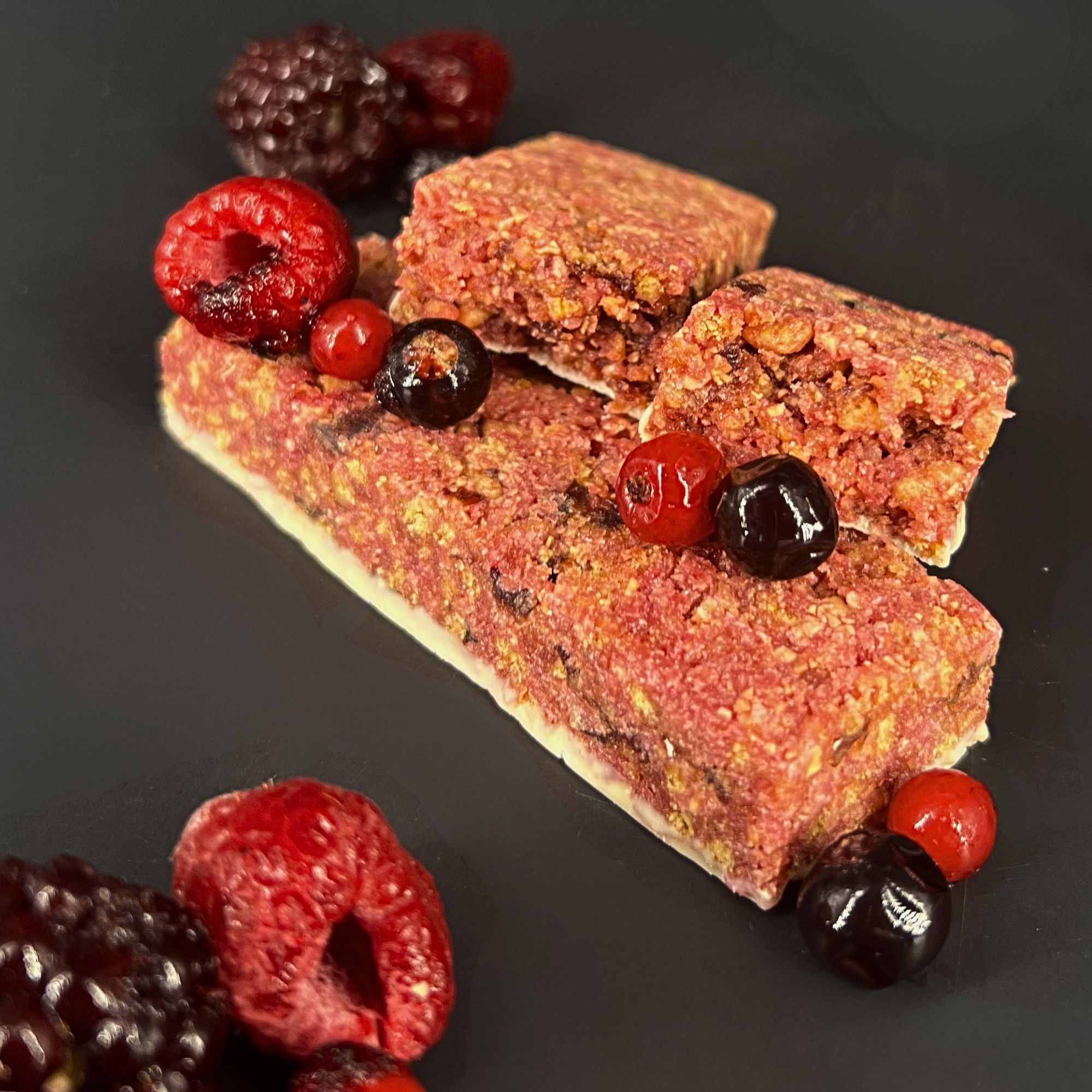 Barre crisp protéinée saveur fruits rouges, présentées avec des fruits rouges, 1Defy nutrition sportive made in bourgogne, made in france