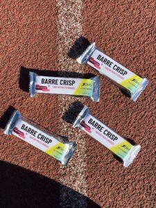 4 Barres crisp protéinées saveur fruits rouges sur uns piste d'athlétisme, 1Defy nutrition sportive made in bourgogne, made in france