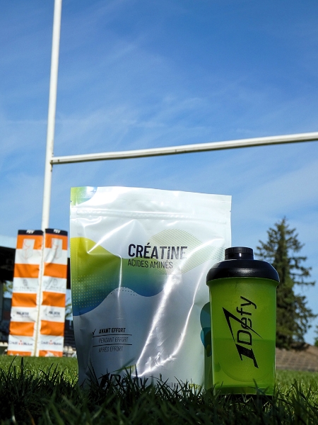 Créatine et son shaker devant des poteaux de rugby - 1Defy Nutrition Sportive Made in Bourgogne