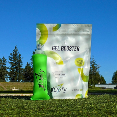 Sachet de Gel Booster, gel énergétique en poudre, saveur pomme, avec une flasque souple entouré de verdure de la marque 1Defy Nutrition Sportive, made in bourgogne