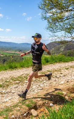 Régis Ruchaud, champion d'ultra-trail et ambassadeur 1Defy, en pleine foulée de course à pied sur un sentier technique de montagne