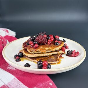Pancakes protéinés avec des fruits rouges et du sirop d'érable en topping, recette issues du blog de 1Defy nutrition sportive made in Bourgogne