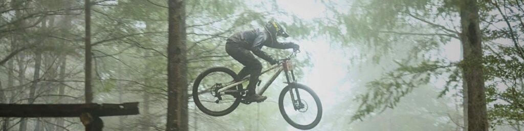 Matys LAUREAU sur son VTT de descente en train de sauter d'un obstacle.