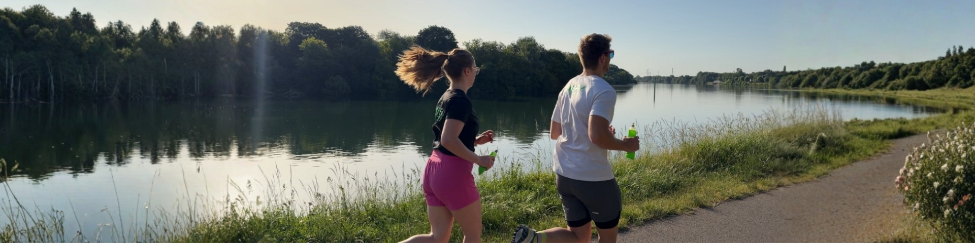 Une femme et un homme courant sur les quais de saone à chalon sur saone, ambassadeurs de la marque 1Defy Nutrition sportive made in bourgogne, photo illustrant un article de blog sur la consommation des électrolytes pour améliorer les performances sportives